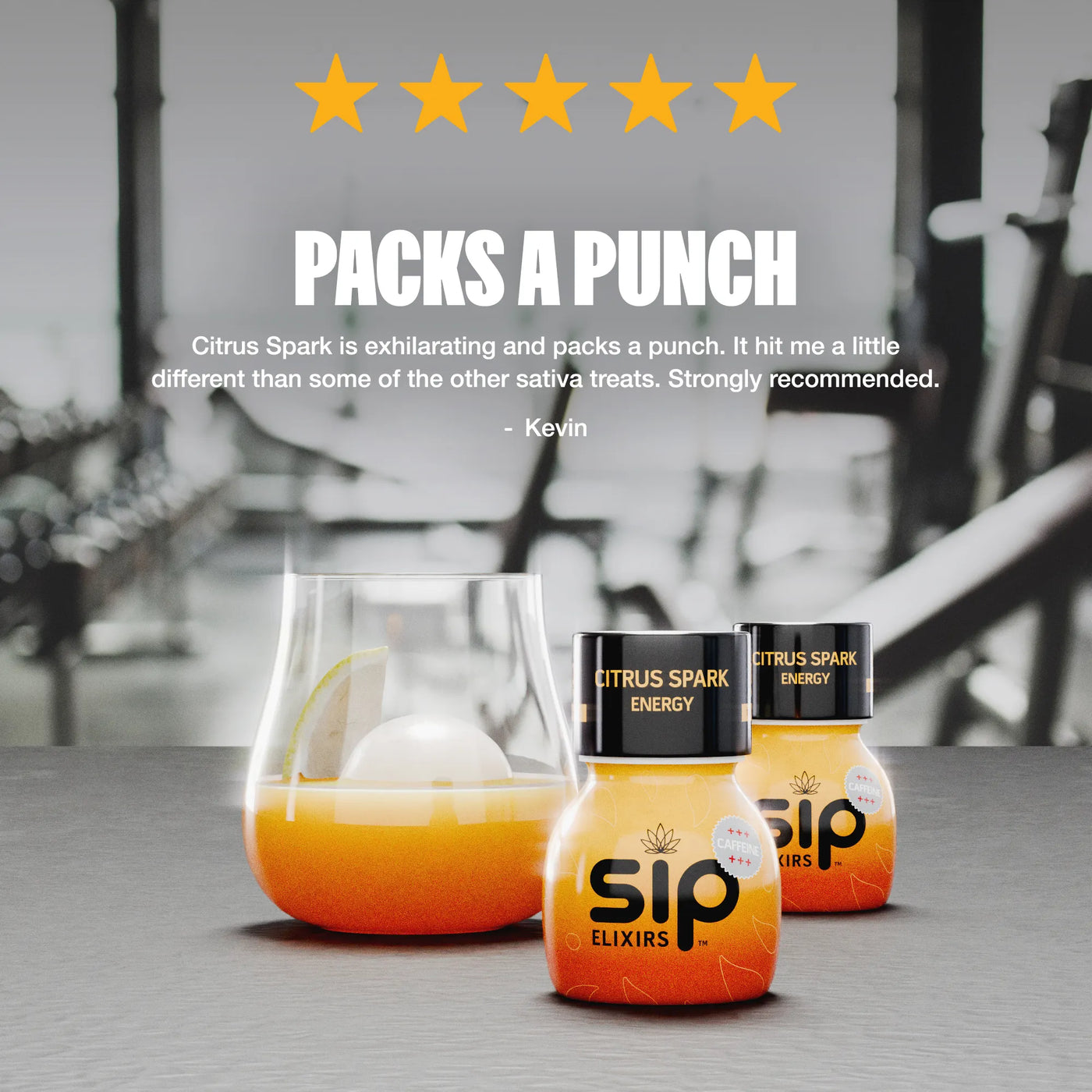 Two bottles of Citrus Spark energy drink with a glass of orange juice on a blurred background.